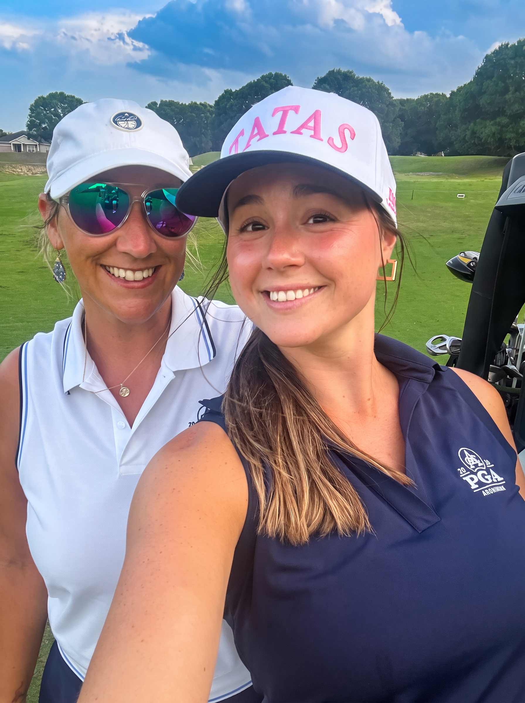The two sisters-in-law who founded Slice Girls Golf, smiling together on the course
